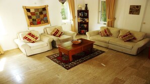 A living room with two white sofas, a wooden coffee table, and a patterned rug.