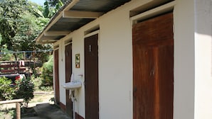 A building with a white exterior and a brown door. - Real family hostel, Hospedaje La Penita, 2 person room  (Altagracia)