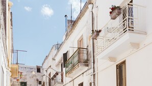 Una estrecha calle adoquinada bordeada por edificios históricos con balcones y un arco de piedra.