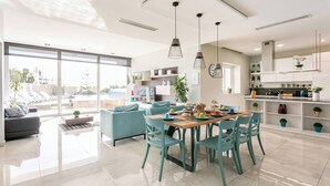 A modern kitchen with a dining area, large windows, and a view of the outdoors. - Villa Dorado with Pool, Sauna, Jacuzzi, Gym & more (Marsaskala)