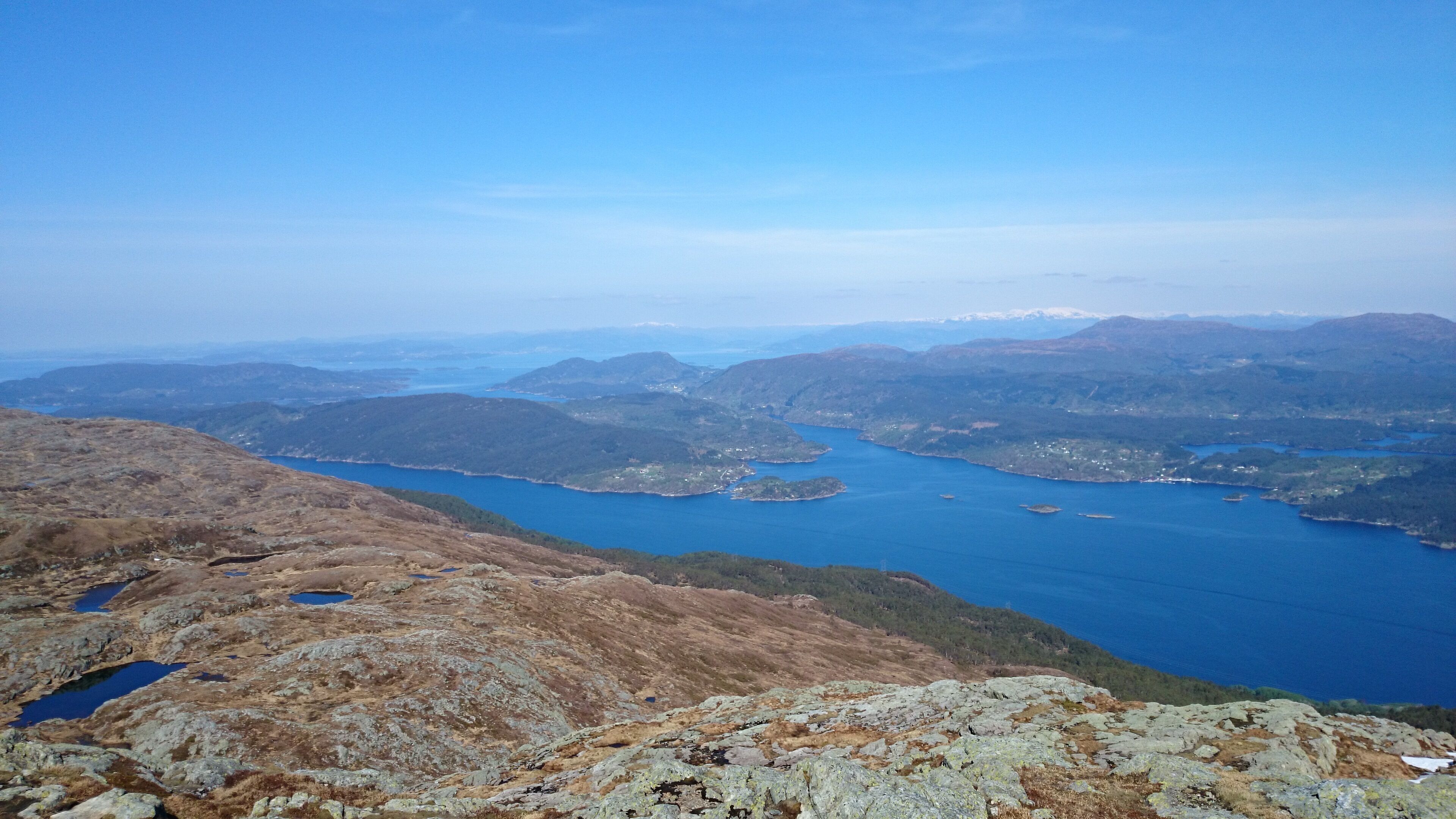 A mountainous landscape with a large body of water surrounded by hills.