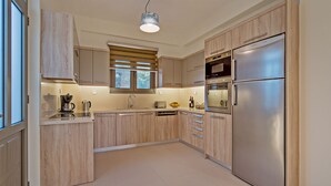 Una cocina moderna con armarios de madera, electrodomésticos de acero inoxidable y un ventanal que proporciona luz natural.