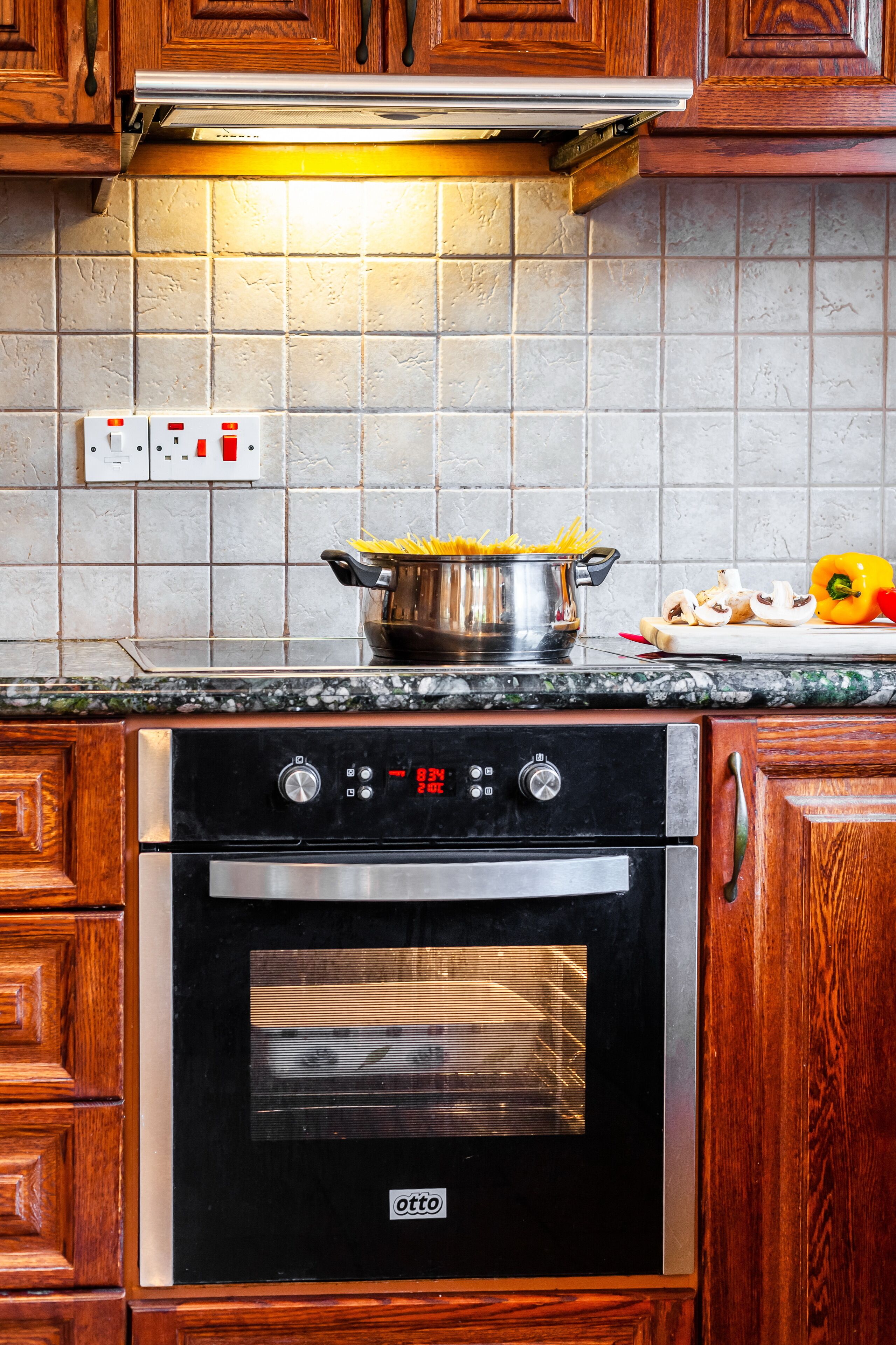 Une cuisine équipée d’une cuisinière, d’un four et d’une casserole remplie de nourriture posée sur le plan de travail.