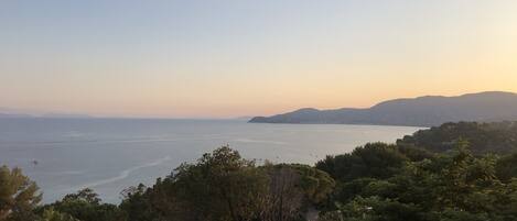 A coastal landscape with a view of the sea and distant hills.