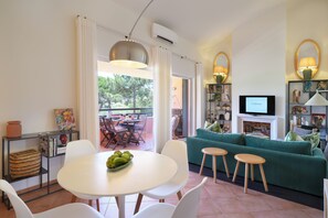 A living room with a green sofa, a white table, and a TV. - bwelcome aroeira beach & golf (Charneca de Caparica)