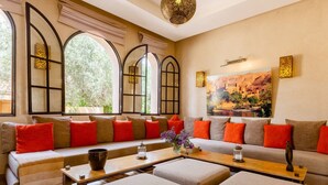 A modern living room with a sofa set, ottomans, a coffee table, and a painting on the wall. - luxury 4 bedroom villa with heated swimming pool, 7 minutes from the center, quiet. (Marrakech)