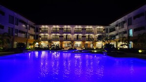 A multi-story hotel with a large illuminated pool in the foreground. - Hotel Oazis Butuan (Butuan)