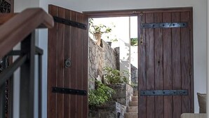 A wooden door leading to a stone staircase.