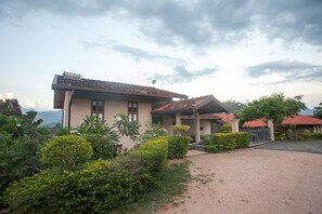 Stunning mountain views surround this two-story residence, featuring a covered patio and lush gardens.