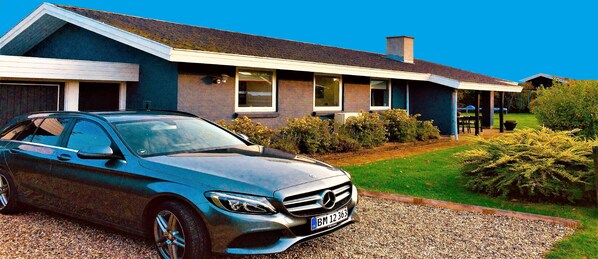 A modern house with a car parked in the driveway.