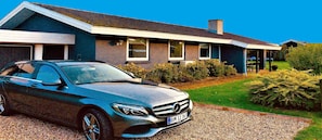 Une maison moderne avec une voiture garée dans l’allée.
