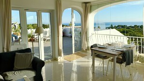 Een moderne woonkamer met een balkon en uitzicht op zee.