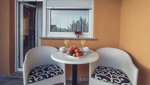 A small outdoor seating area with two wicker chairs and a table, a window with a view, and a fruit and juice tray on the table. - COZY HOUSE HEATED POOL, NEAR BEACH IN SPLIT COUNTY (Imotski)