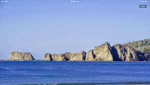 A coastal landscape with a sandy beach and rocky formations in the background. - MODERN AND MAGICAL VILLA WALKING DISTANCE FROM THE BEACH!  (Guanacaste)