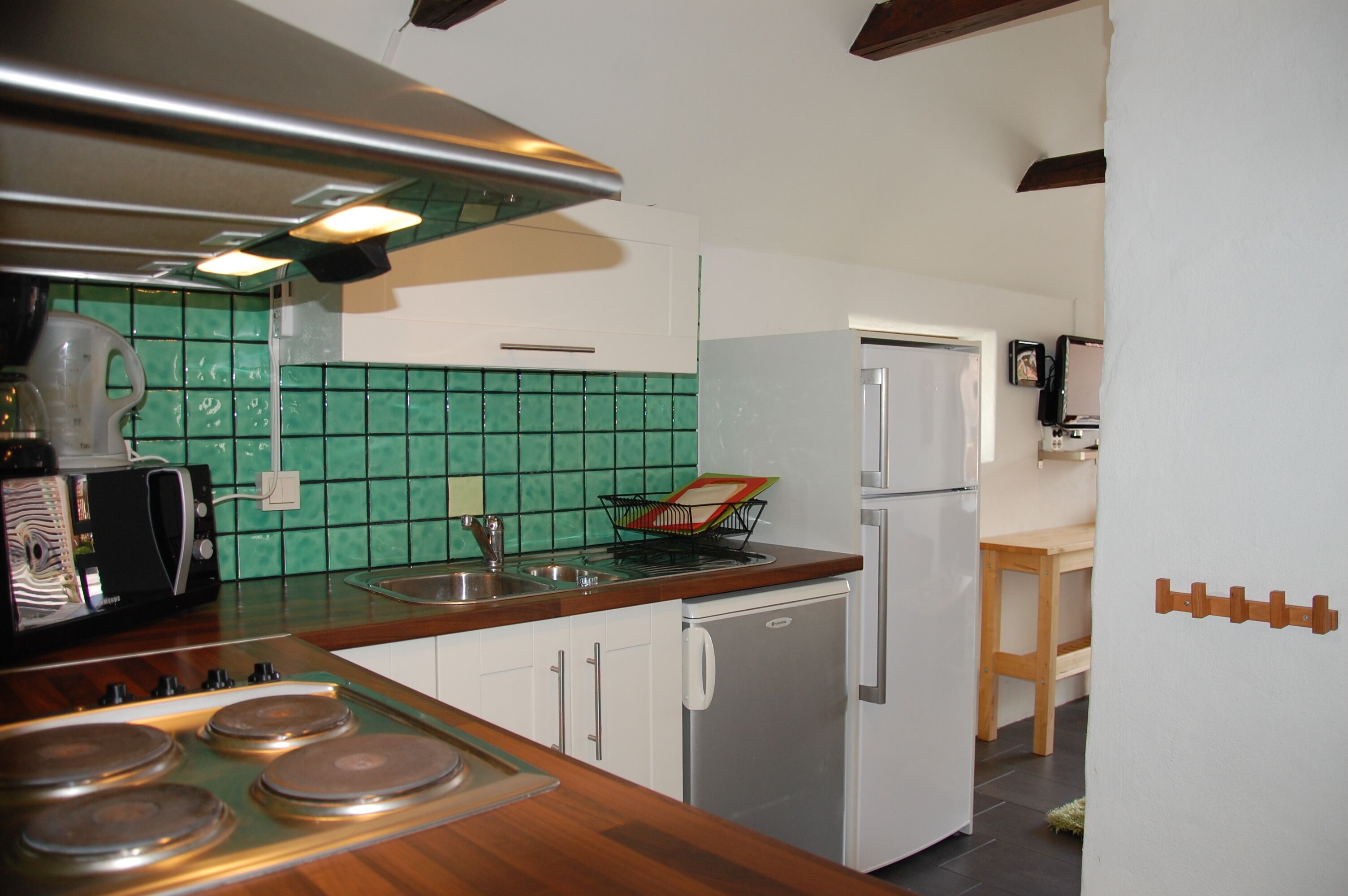 Una cocina con microondas, estufa, pileta y refrigerador.