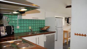 Una cocina con microondas, estufa, pileta y refrigerador.