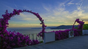 Un balcon avec vue sur la mer et un paysage montagneux.