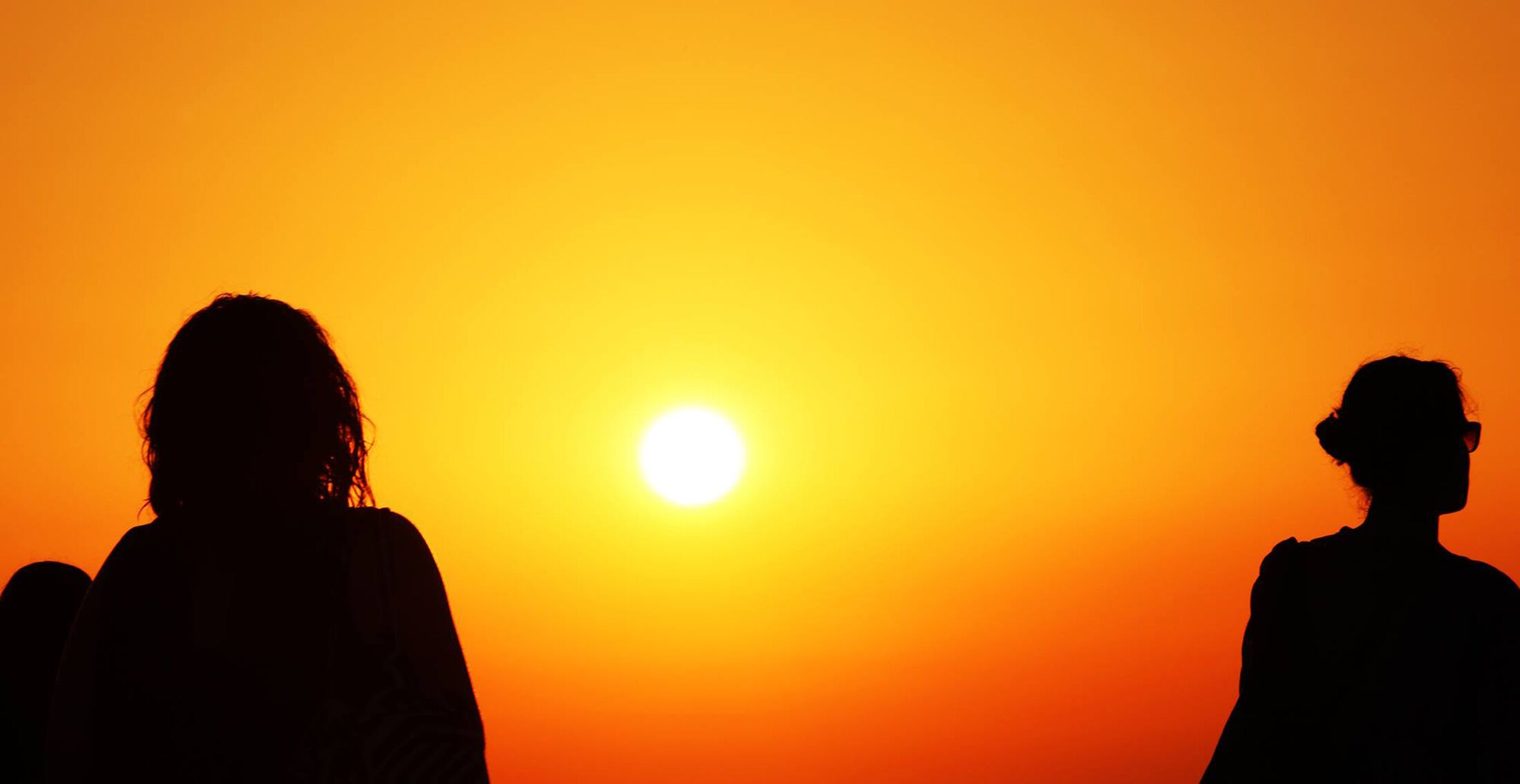 Silhouetten tegen een zonsondergang.