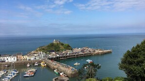 Une ville côtière dotée d’une jetée, de bateaux et d’un phare.