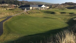 Un parcours de golf doté d’un club-house et d’un chemin menant à celui-ci.