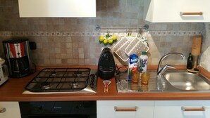 A kitchen with a gas stove, a coffee maker, a kettle, a sink, and a dish rack. - PEACE AND PRIVACY AT HOME "Il CORBEZZOLO" (Poggio Catino)