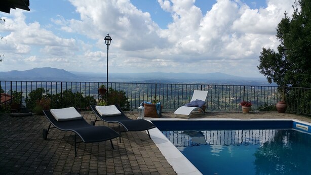 A poolside area with lounge chairs and a view of mountains. - PEACE AND PRIVACY AT HOME "Il CORBEZZOLO" (Poggio Catino)