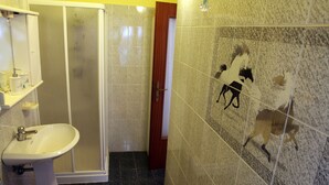 Un baño con lavabo, espejo y ducha.