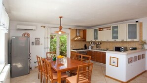 Una cocina moderna con una isla central, una mesa de comedor de madera y sillas.