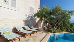 Zona de piscina con sillones de descanso y una pileta.