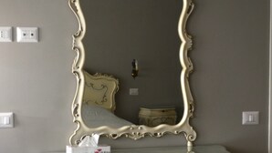 A vintage-style vanity with a mirror, floral patterns, and a small bedside table. - Charming appartment Ideal for 4 guests, in San Pietro, 2 bedrooms & 2 bathrooms  (Roma)