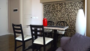 A dining area with a tiled backsplash, a white door, and a sofa. - Charming appartment Ideal for 4 guests, in San Pietro, 2 bedrooms & 2 bathrooms  (Roma)