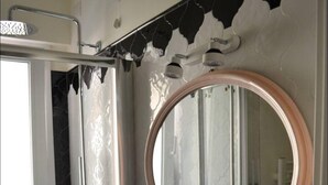 A bathroom with a white sink, a round mirror, and a shower. - Charming appartment Ideal for 4 guests, in San Pietro, 2 bedrooms & 2 bathrooms  (Roma)