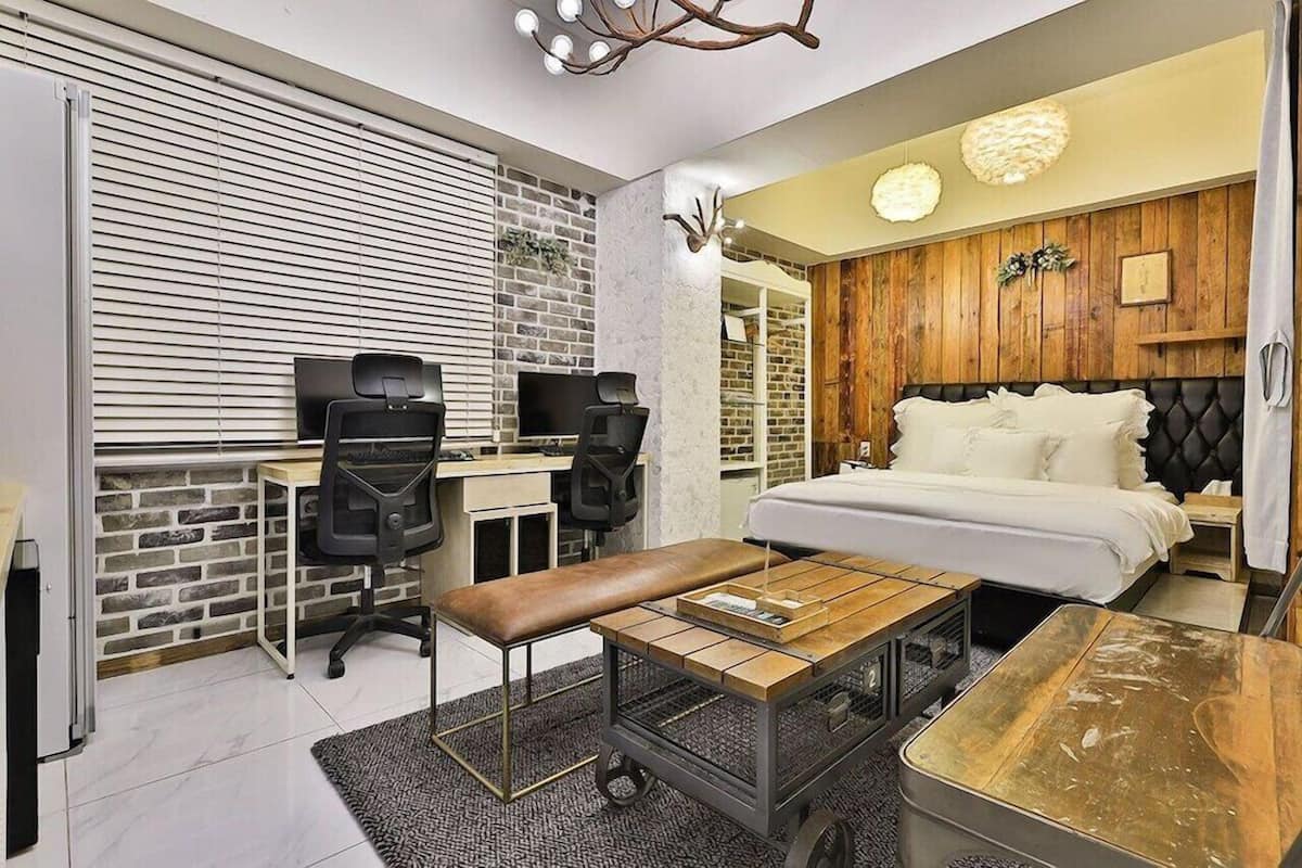 Un dormitorio moderno con cama, escritorio, sillas y un banco.