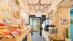 Un pasillo de hotel con un letrero que dice 'BRUNCH & CAFE', un candelabro y un letrero en la pared que dice 'THE GOOD NIGHT'.