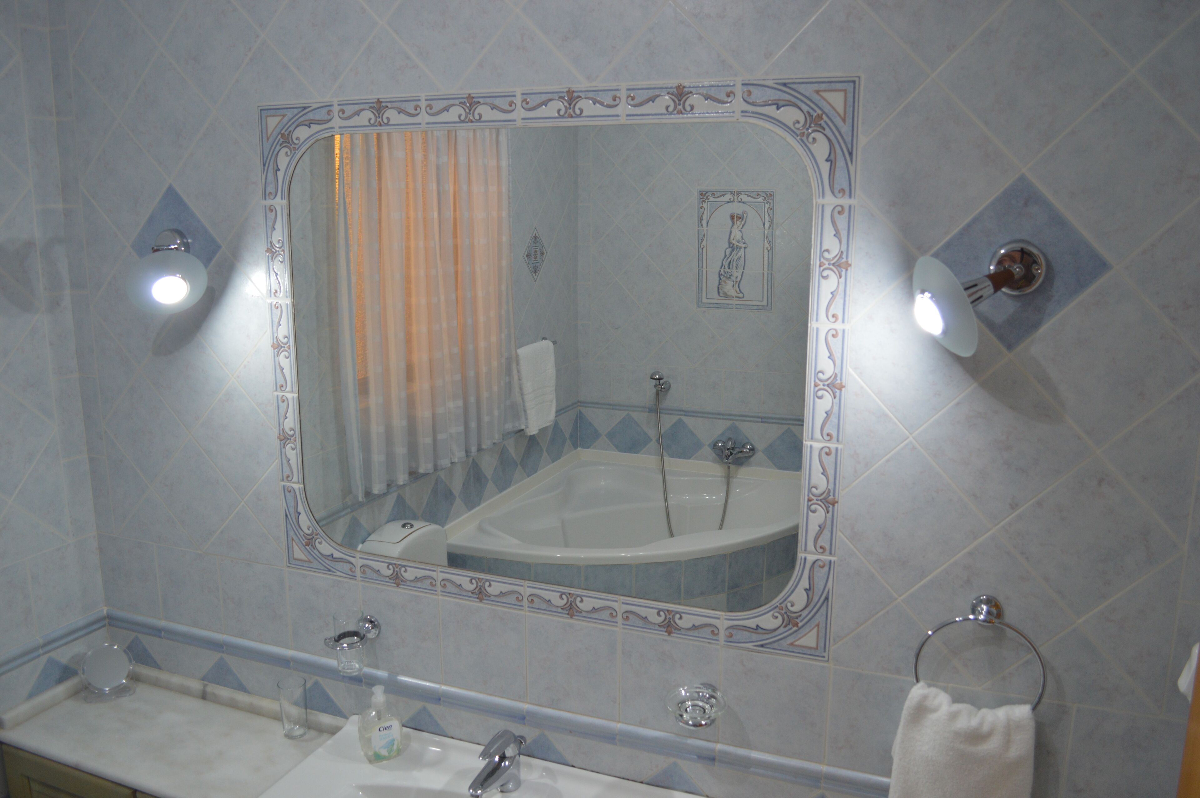 A bathroom with a bathtub, a sink, and a mirror.