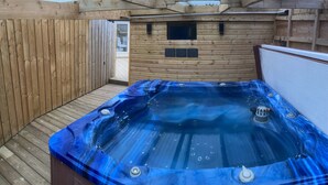A wooden cabin with a hot tub and a small window. - 5* Barn Conversion c/w hot tub, sauna, games room, 1/4 acre enclosed games (Stocksfield, Northumberland)