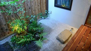 A small garden area with a wooden fence, a bench, and a stone pathway. - Kyoto Guest House Nanni Saiin (Kyoto)