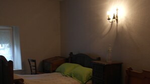 A bedroom with two beds, a dresser, and a nightstand.