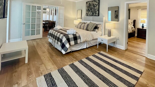 A bedroom with a bed, bedside tables, a rug, and a ceiling fan.