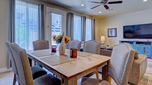 A dining area with a wooden table, six upholstered chairs, a vase with flowers, and a ceiling fan. -  St George, near Zion 2 king beds, 2 pools/hot tubs, fish pond  (Washington)