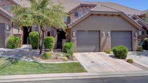 A two-story house with a garage, a well-maintained lawn, and a tree in the front yard. -  St George, near Zion 2 king beds, 2 pools/hot tubs, fish pond  (Washington)