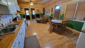 A wooden interior with a kitchen, dining area, and a living room.
