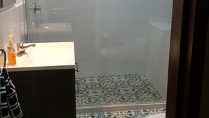A bathroom with a shower, toilet, and sink.
