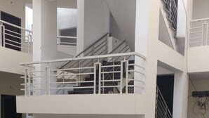 Um edifício com vários andares, corrimãos e escadarias brancos.