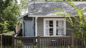Una casa pequeña con un porche, una puerta y una ventana.