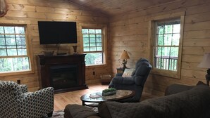 A cozy cabin interior with wooden walls, a fireplace, a television, and comfortable seating. - ENJOY A QUIET GETAWAY AT MOUNTAIN VIEW CABIN RENTALS (New Market)
