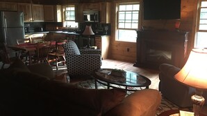 A cozy cabin interior with a dining area, a fireplace, and a television. - ENJOY A QUIET GETAWAY AT MOUNTAIN VIEW CABIN RENTALS (New Market)