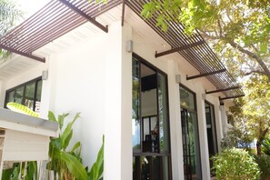 A modern building with large windows, a white exterior, and a wooden pergola. - Aana Residence Resort (Rayong)