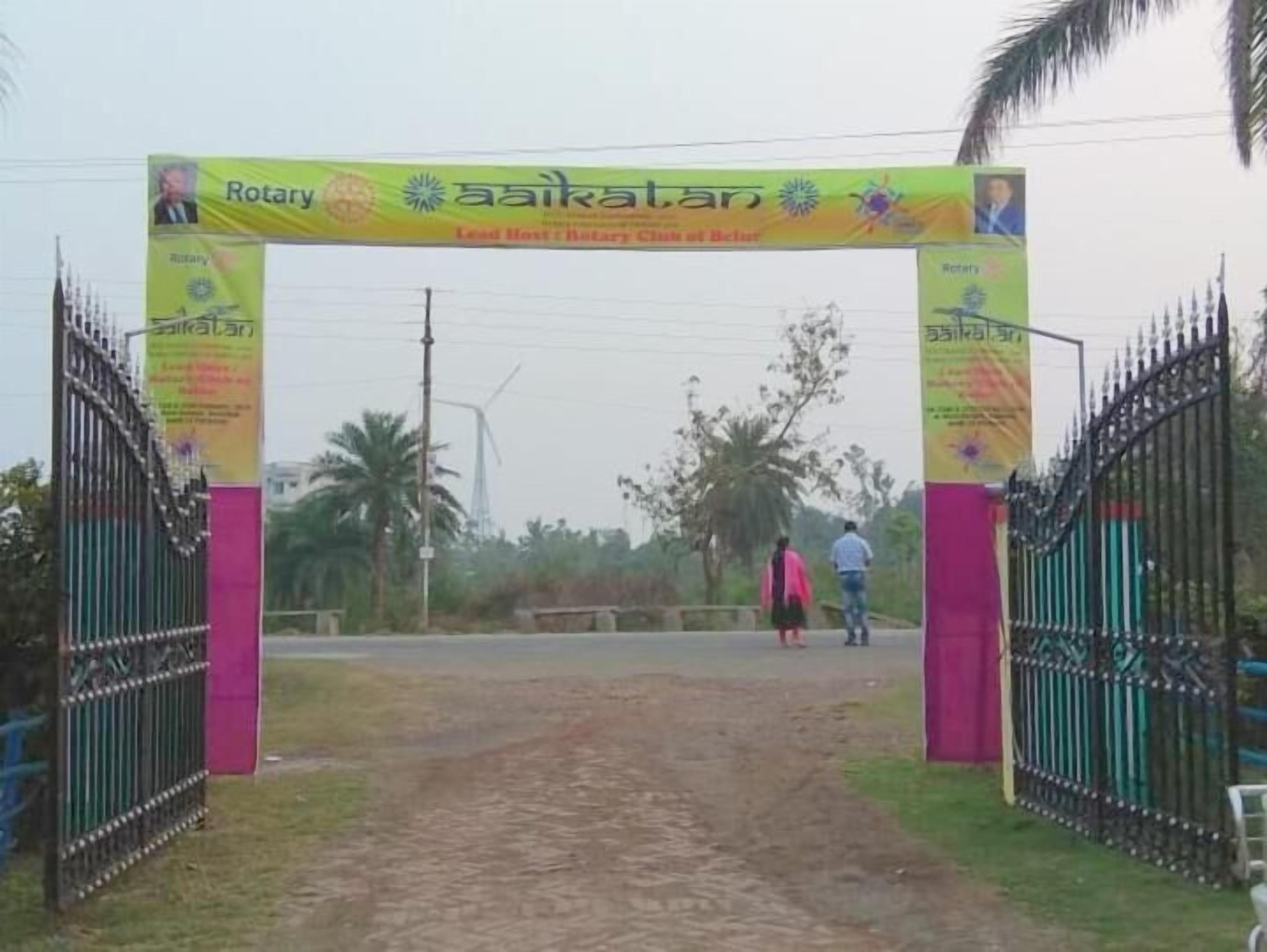 Een poort met een spandoek voor Rotary International en een bord met de tekst 'aaikalatan'.