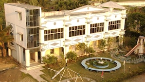 A large building with a central courtyard, a playground, and a water slide. - Hotel Deepak (Kakdwip)